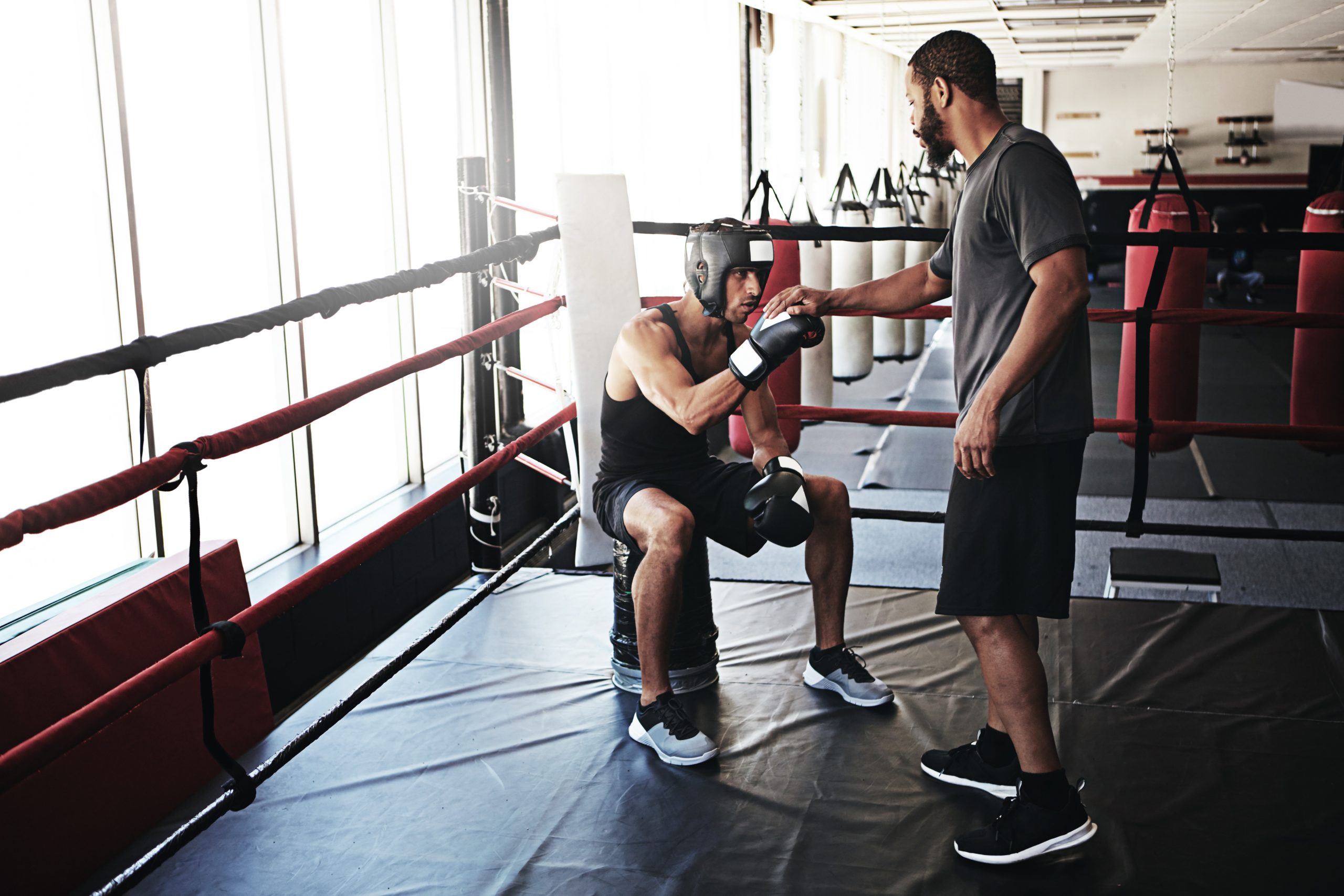 Shot of a man training in the boxing ring with a coach